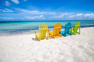 Four colorful beach chairs on a beach
